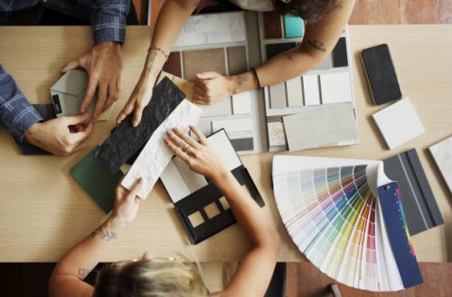 interior designer discussing tile and color options with clients in her office - home decoration stock pictures, royalty-free photos & images