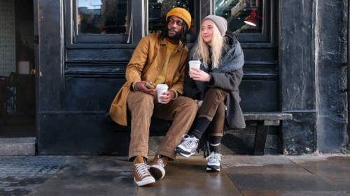 interracial couple enjoying coffee outdoors - fashion stock pictures, royalty-free photos & images