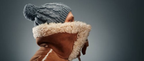it's so cold. man wearing leather coat with fur collar and knit hat - fashion stock pictures, royalty-free photos & images