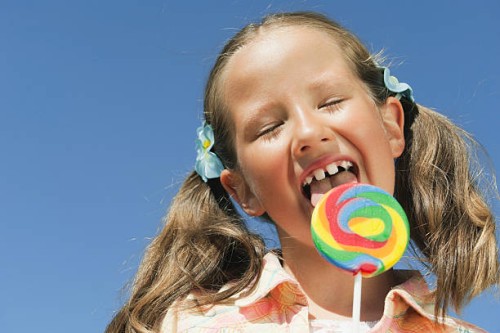 italy, south tyrol, girl (6-7) licking lollypop, portrait, close-up - junk food stock-fotos und bilder