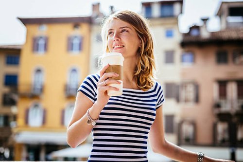 italy, udine, portrait of smiling young woman with coffee to go - junk food stock pictures, royalty-free photos & images