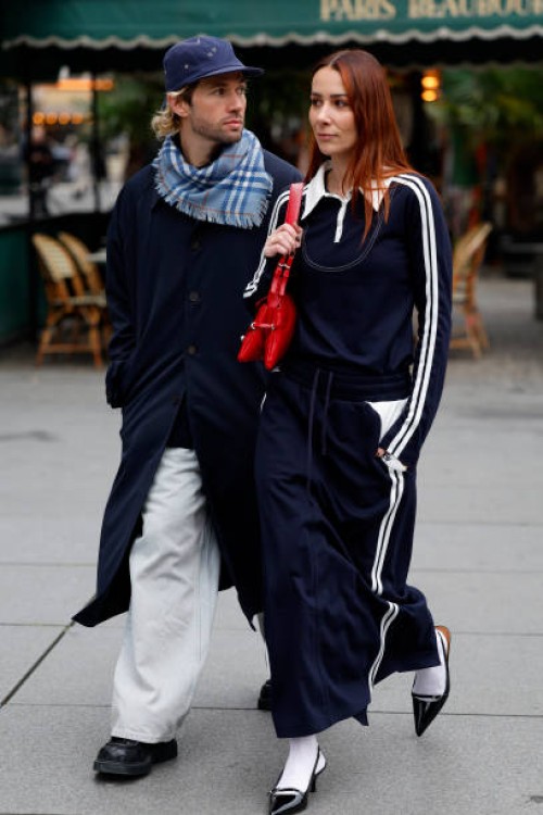 Jean-Sebastien Roques wears blue trench coat, light blue checked scarf, blue hat, white jeans, black loafers , and Alice Barbier wears blue polo neck...