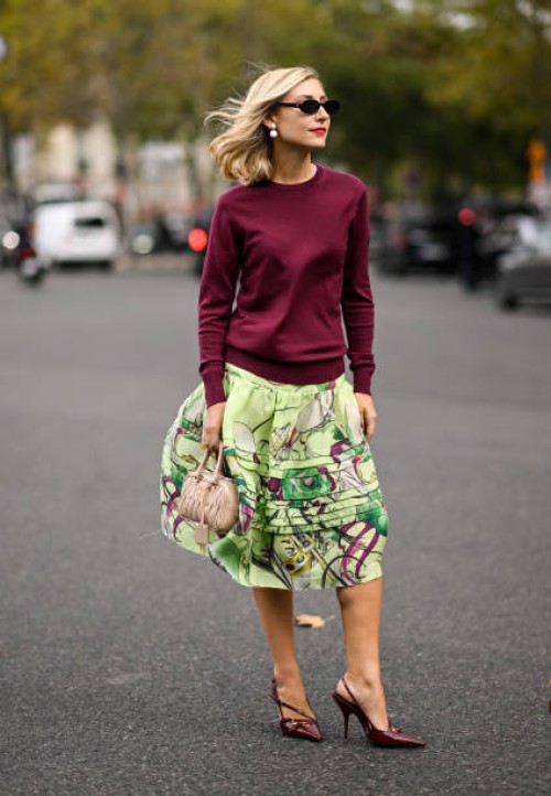 Jenny Walton is seen wearing a maroon sweater, green floral skirt, Miu Miu bag and black sunglasses with pearl earrings outside the Miu Miu show...
