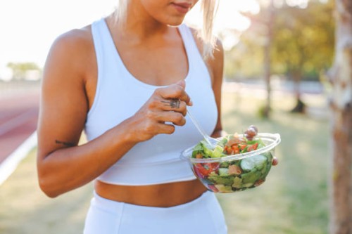jeune femme mangeant une salade saine après l’entraînement. concept de remise en forme et de mode de vie sain. - food photos et images de collection