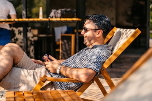 jeune homme se relaxant sur la chaise longue dans la cour arrière - garden decoration photos et images de collection
