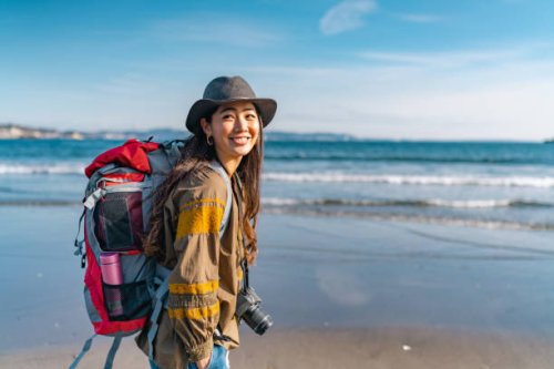 jeune voyageuse qui aime passer du temps à la plage pendant ses vacances - travel photos et images de collection