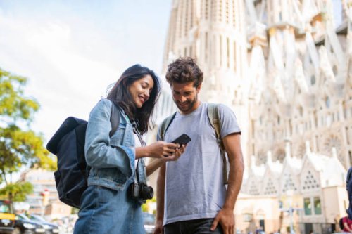 jong toeristenpaar dat slimme telefoon in barcelona bekijkt - travel stockfoto's en -beelden