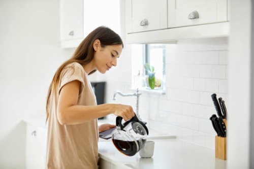 jonge vrouw koffie in beker thuis gieten - coffee stockfoto's en -beelden
