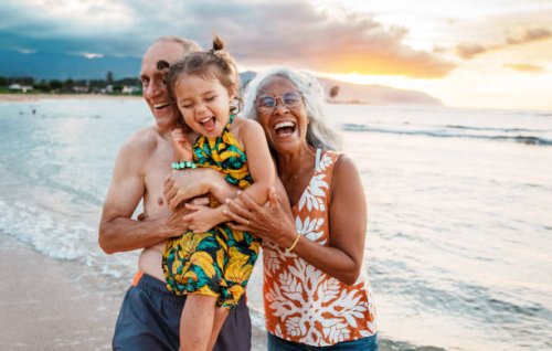 joyful eurasian girl playing at the beach with her grandparents - travel stock pictures, royalty-free photos & images