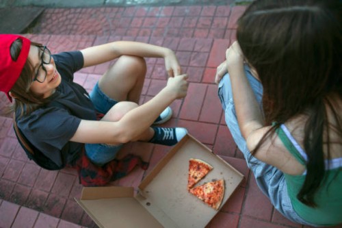 joyful, happy friends eating pizza outside - junk food stock pictures, royalty-free photos & images