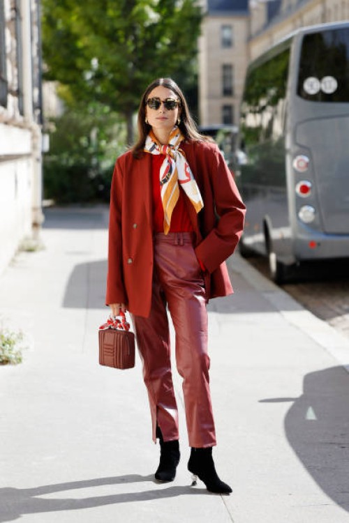 Julia Haghjoo wears red top, red blazer, red leather pants, red bag, black boots, printed scarf, outside Hermes, during Womenswear Spring/Summer 2025...