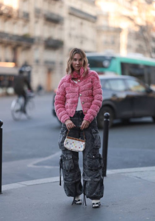 Karin Teigl seen wearing Chanel pink fluffy cardigan jacket, The Attico grey oversized cargo denim jeans, Loewe white tank top, white socks, Chanel...