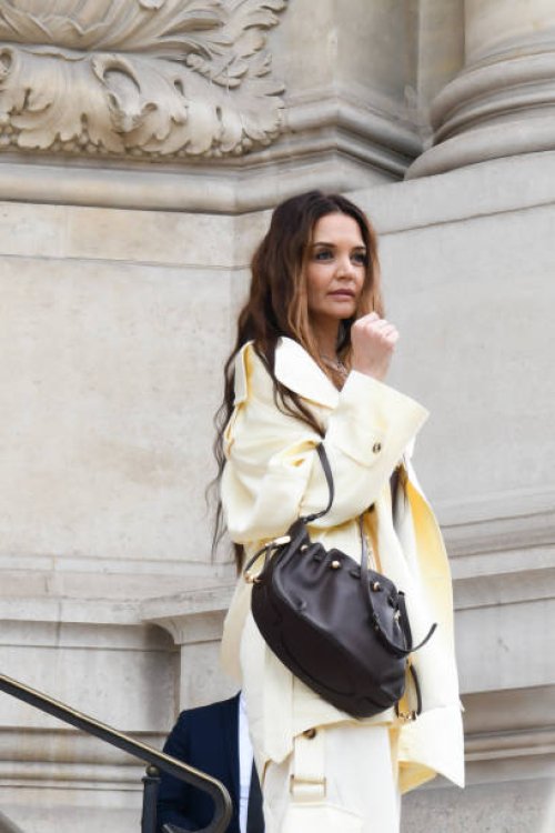 Katie Holmes wears brown top, butter yellow jacket, matching cargo trousers, brown bag, outside Zimmermann, during the Womenswear Fall/Winter...