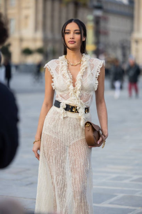 Kelsey Merritt wears white transparent, belted laced dress, brown bag outside Dior during the Womenswear Fall/Winter 2025/2026 as part of Paris...