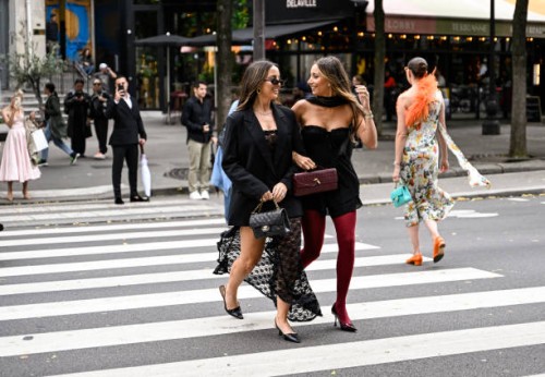 Kerry Denevan is seen wearing a black blazer, laced dress, black heels and sunglasses with a Chanel bag with Lya Mariella is seen wearing a Windsor...