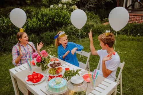 kids are sitting near decorated birthday table in home yard. - garden decoration stock pictures, royalty-free photos & images