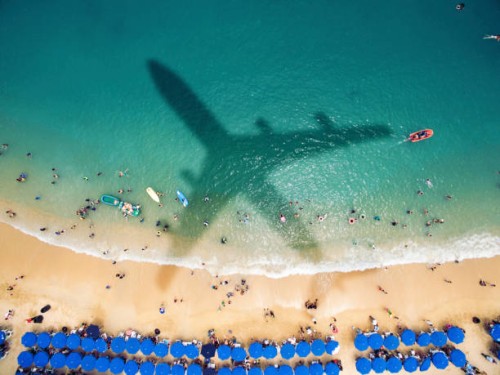 l’ombre de l’avion sur une plage bondée - travel photos et images de collection