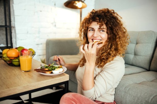la femme prend le petit déjeuner dans le salon - food photos et images de collection