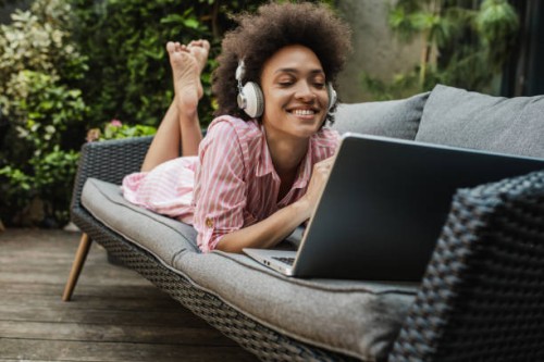 la femme se détend et utilise un ordinateur portable dans la cour arrière - garden decoration photos et images de collection