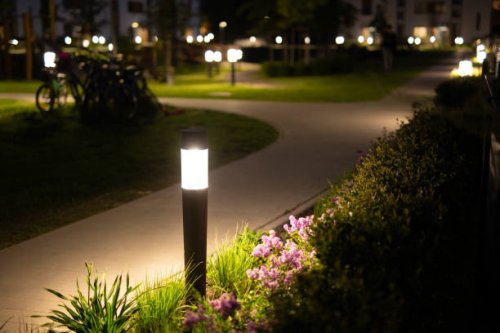lamps shining on the sidewalk in an elegant grassy courtyard at night - garden decoration stock pictures, royalty-free photos & images