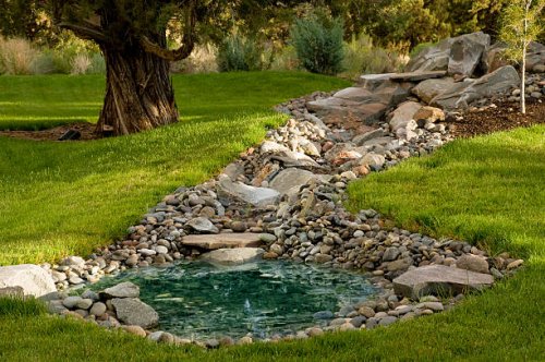 landscaped yard with pond on grass hill - garden decoration stock pictures, royalty-free photos & images