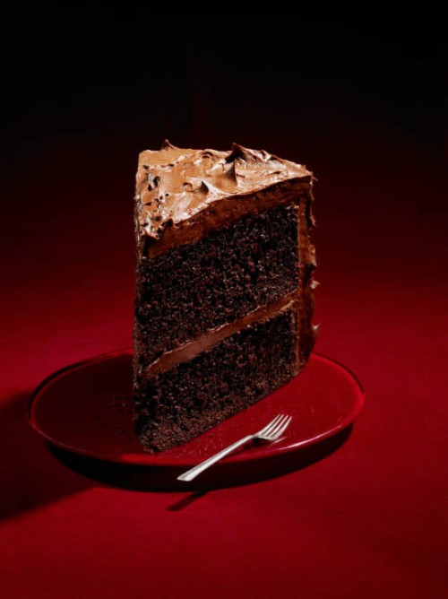 large slice chocolate cake on red background - junk food stock pictures, royalty-free photos & images
