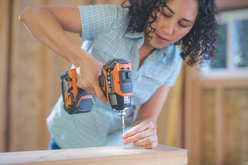 latino female using a cordless drill to drill screw - home decoration stock pictures, royalty-free photos & images
