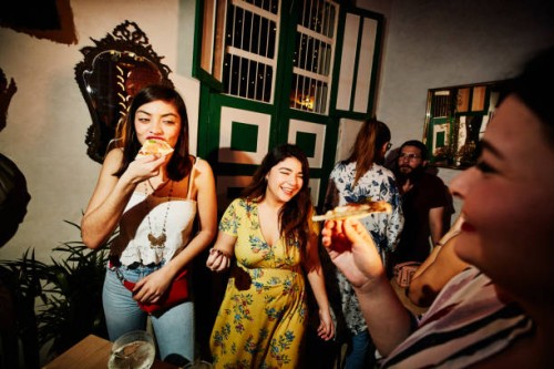 laughing female friends enjoying food during party in night club - fashion stock pictures, royalty-free photos & images
