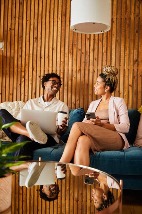 laughing young businesspeople using different devices during an office break - coffee stock pictures, royalty-free photos & images