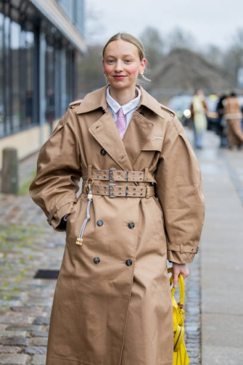 Laura Schulte wears brown belted trench coat, yellow Balenciaga bag outside Munthe during the Copenhagen Fashion Week Autumn/Winter 2025 on January...