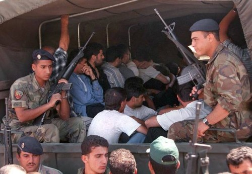 Lebanese army soldiers take away members of the South Lebanese Army who surrendered in the village of Beit Yahoun 22 May 2000. More than 200 SLA...