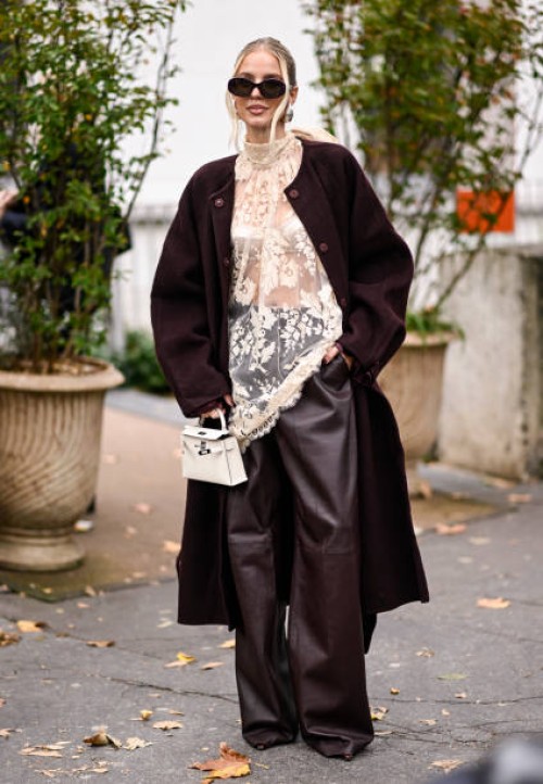 Leonie Hanne is seen wearing a Zimmermann coat, burgundy Zimmermann pants, sheer laced Zimmermann top and white bag with black sunglasses outside the...