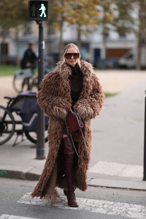 Leonie Hanne is seen wearing burgundy oversized shield frame sunglasses with wide temples from Stella McCartney, silver drop-shaped earrings from...