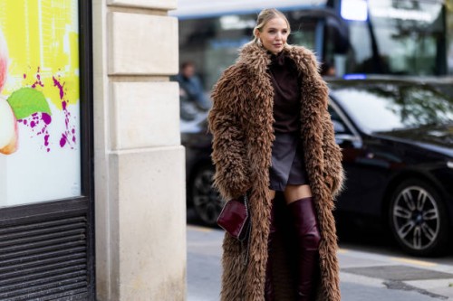 Leonie Hanne wears knee high leather heeled burgundy boots, a long beige teddy coat, a burgundy top, a grey mini skirt and a burgundy leather Stella...