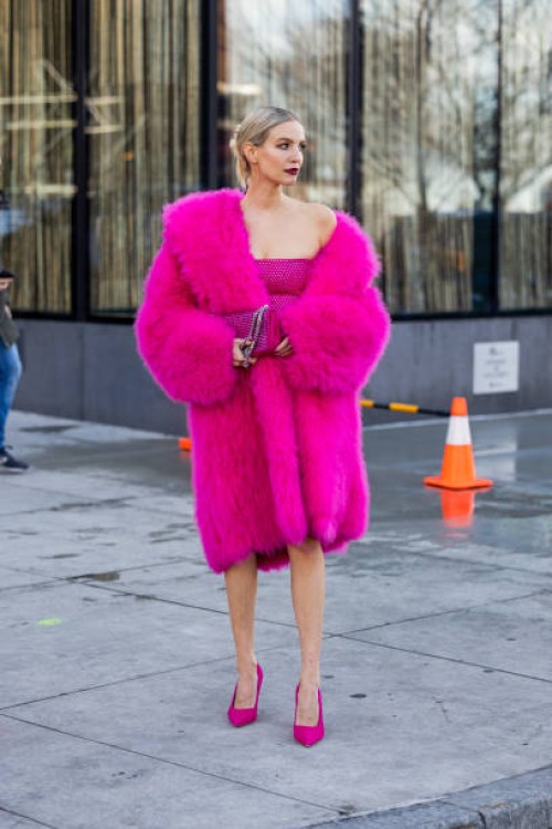 Leonie Hanne wears pink coat, dress, bag, heels outside Michael Kors New York Fashion Week during on February 15, 2023 in New York City.