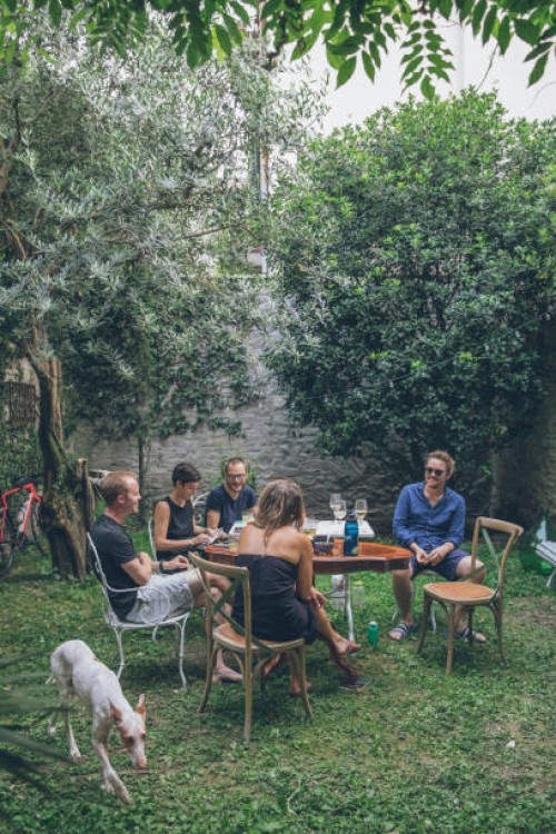 les amis déjeunent dans une cour luxuriante, en été - garden decoration photos et images de collection