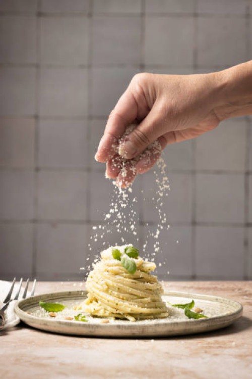 linguine pasta on plate with pesto and basil human hand - food stock pictures, royalty-free photos & images