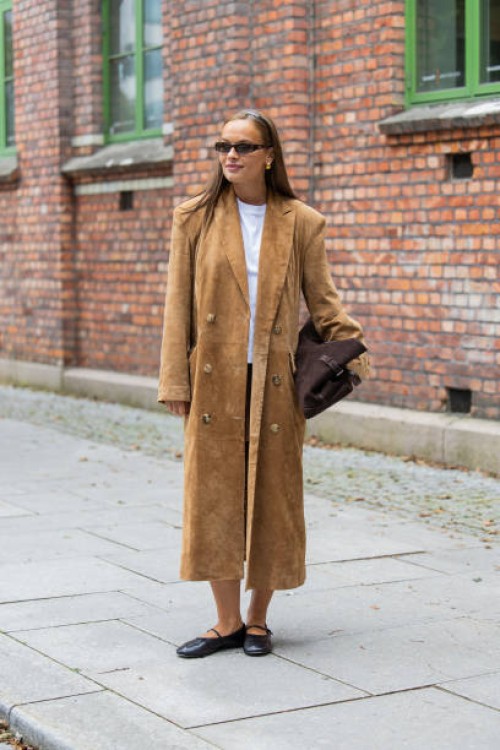 Lisa Alexandra wears brown wild leather coat, bag, skirt, white tshirt at Oslo Fashion Week 2024 on August 27, 2024 in Oslo, Norway.