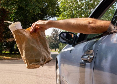 litter being dropped out of a car window. - junk food stock pictures, royalty-free photos & images