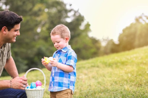 little boy, father hunting easter eggs at park. - garden decoration stock pictures, royalty-free photos & images