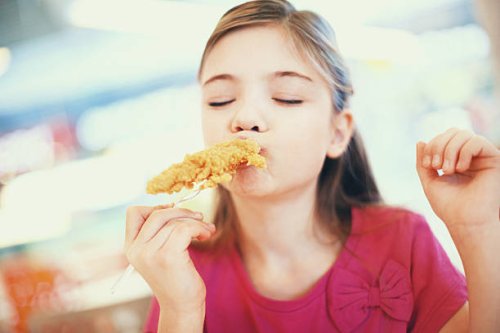 little girl eating fried chicken. - junk food stock pictures, royalty-free photos & images