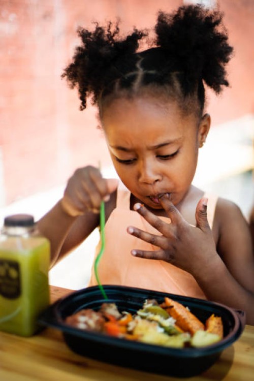 little girl eating take out food outdoors. - junk food stock pictures, royalty-free photos & images