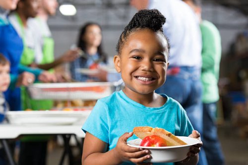 little girl holding bowl at soup kitchen or food bank - food stock pictures, royalty-free photos & images