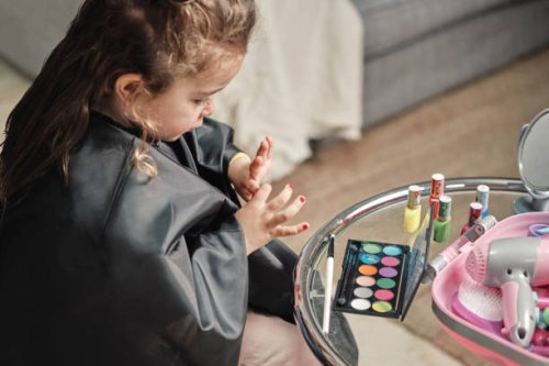 little girl is removing the paint from her nails - nails art photos et images de collection