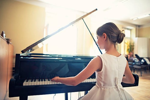 little girl playing on grand piano - concert stock pictures, royalty-free photos & images
