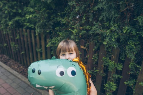 little girl with large balloon in the yard - garden decoration stock pictures, royalty-free photos & images