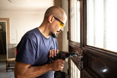 locksmith changes a lock at home with a battery drill - home decoration stock pictures, royalty-free photos & images