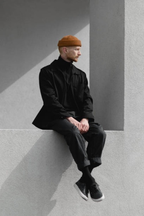 lonely stylish young man on the windowsill - fashion stock pictures, royalty-free photos & images