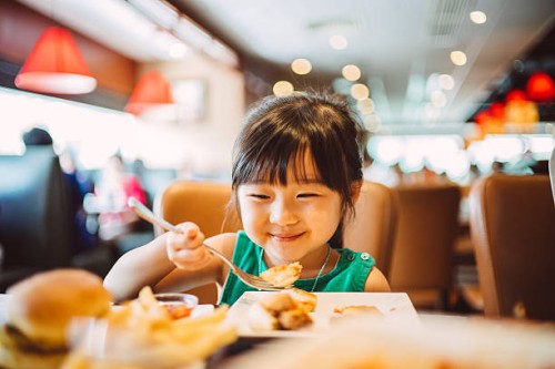 lovely little girl having meals joyfully - junk food stock pictures, royalty-free photos & images