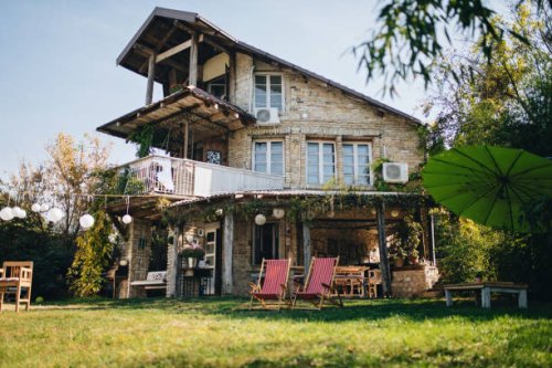lovely stone house with a big front yard and a porch swing - garden decoration stock pictures, royalty-free photos & images